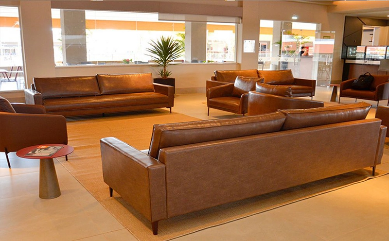 Sala de estar de um apartamento com sofás de couro marrom.