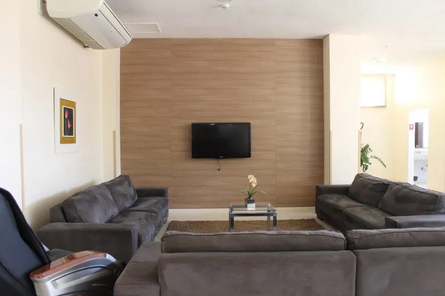 Detalhe do quarto com frigobar e TV.