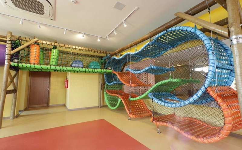 Espaço kids do hotel com brinquedo de escalada e túneis.