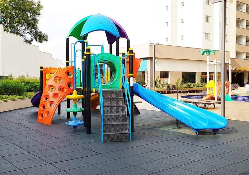 Playground externo para crianças com escorregador e outros brinquedos.