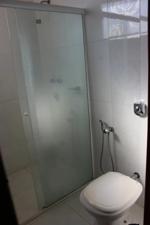 Banheiro privativo com box de vidro e ducha.