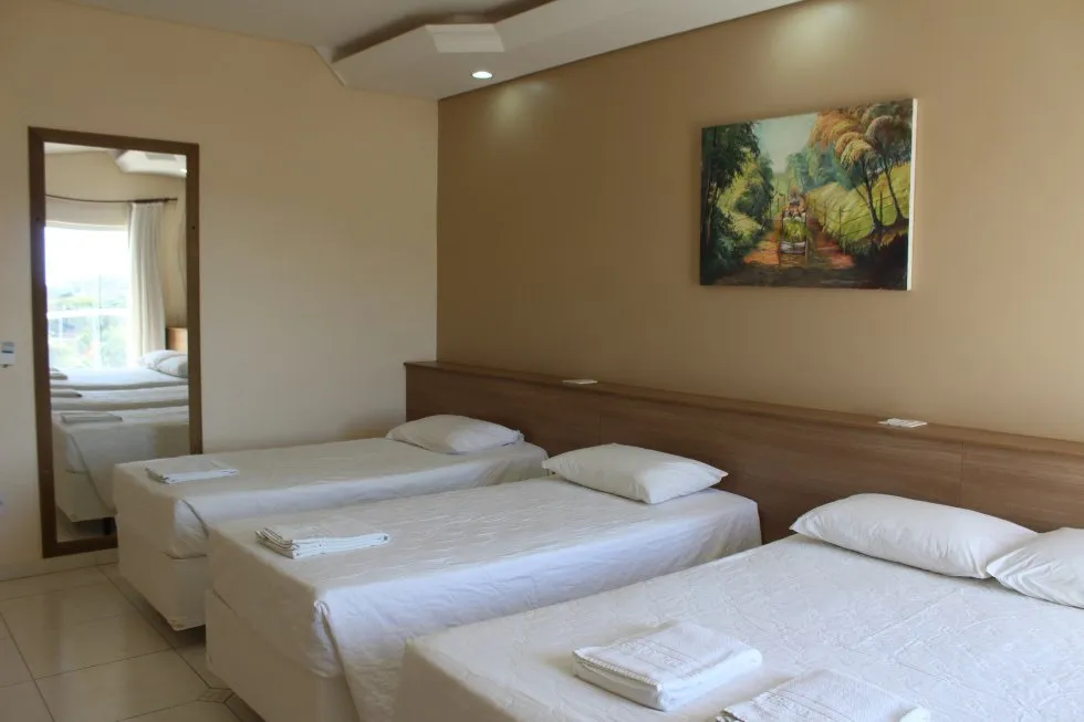 Quarto família com três camas de solteiro.