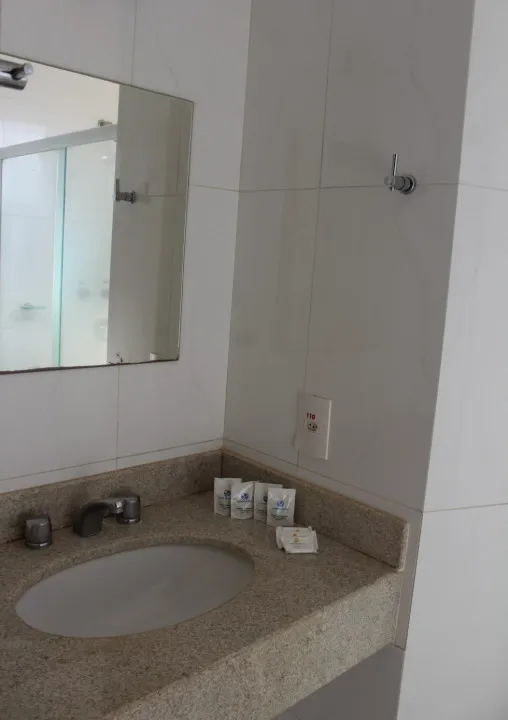 Detalhe do banheiro com acabamento em azulejo claro.