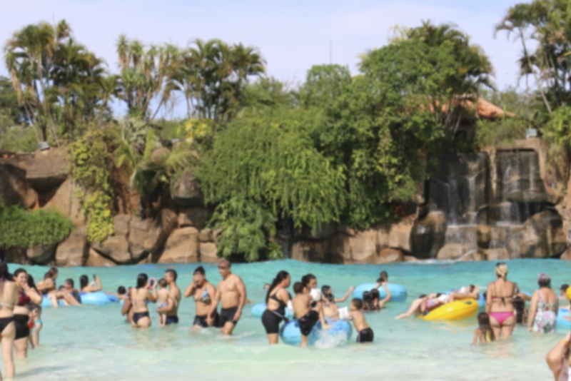 Close de uma boia de borracha amarela e azul flutuando na água da piscina.