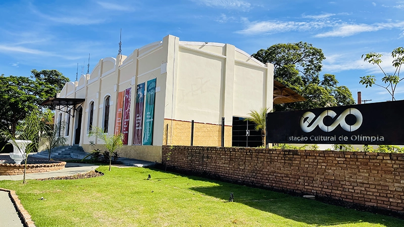 Fachada de prédio histórico branco com gramado em Olímpia